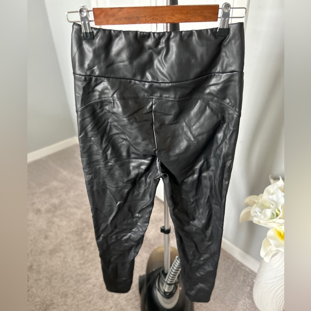 Black faux leather leggings. Stretchy when worn. Flexible fabric. Comfortable.